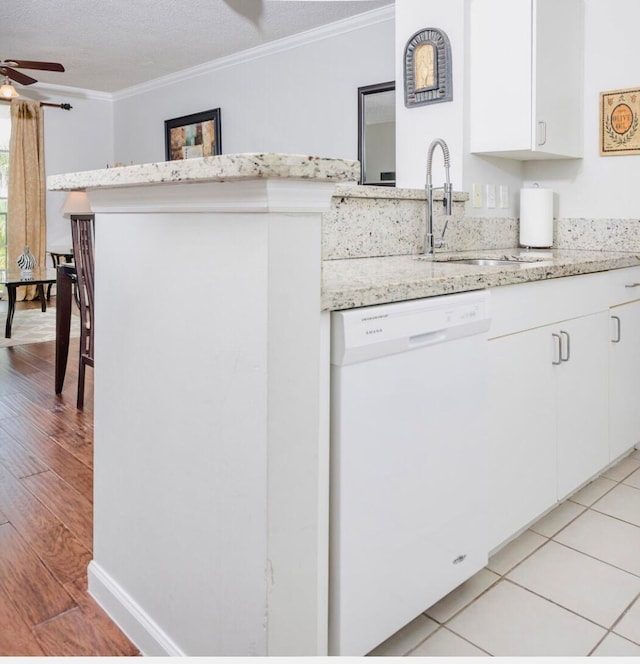 kitchen with dishwasher, sink, ceiling fan, light wood-type flooring, and a textured ceiling