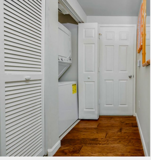 washroom with dark hardwood / wood-style floors and stacked washer and clothes dryer