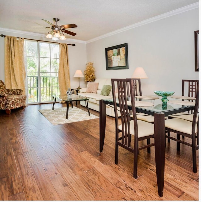 dining space featuring ceiling fan, wood-type flooring, and crown molding