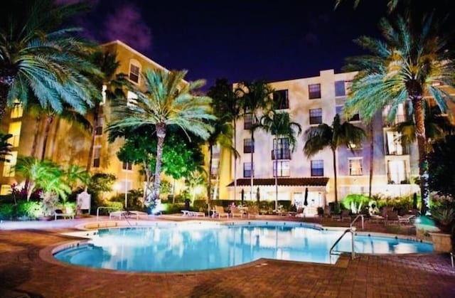 view of pool at twilight