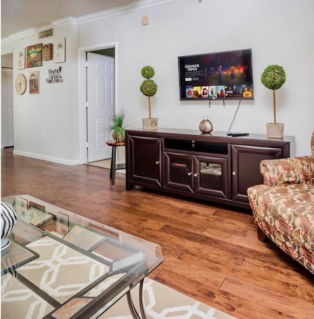 living room with hardwood / wood-style floors and crown molding