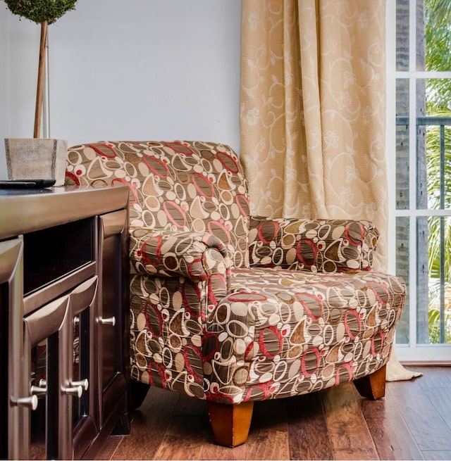 living area with a wealth of natural light and hardwood / wood-style flooring