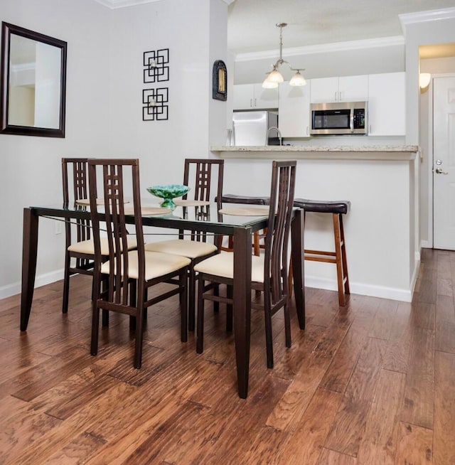 dining room with a notable chandelier, dark hardwood / wood-style flooring, and ornamental molding