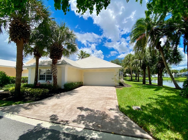 view of front facade with a water view, a garage, and a front yard