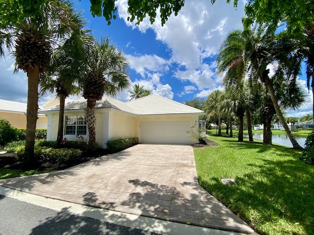 view of front facade with a water view, a garage, and a front yard