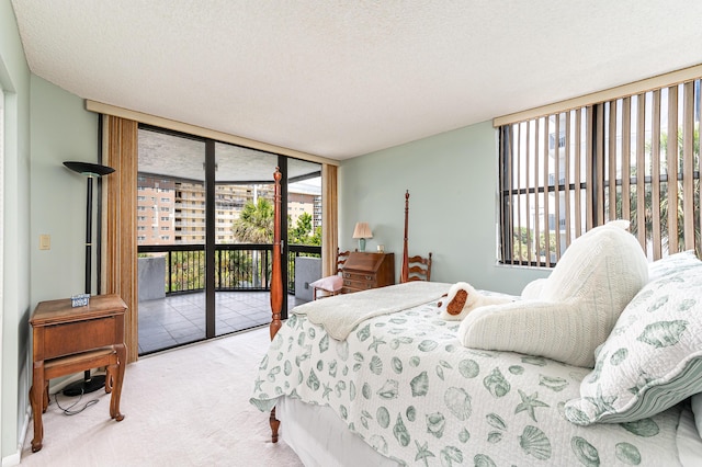 carpeted bedroom featuring a wall of windows, a textured ceiling, and access to outside