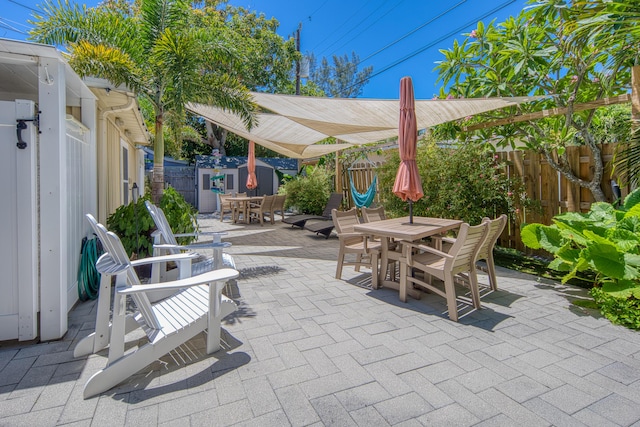 view of patio featuring outdoor dining space, an outdoor structure, and a fenced backyard