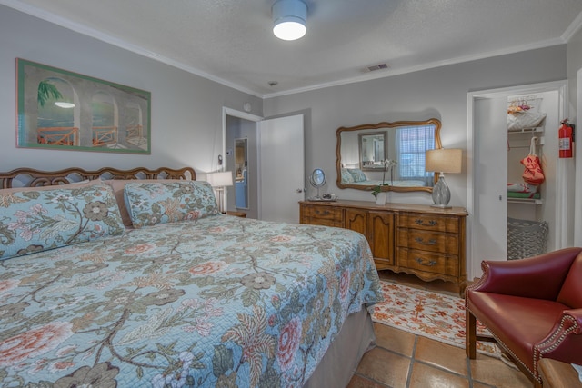 bedroom featuring ceiling fan, a textured ceiling, and ornamental molding