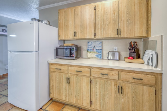 kitchen featuring light brown cabinetry, ornamental molding, a textured ceiling, light tile patterned floors, and white refrigerator