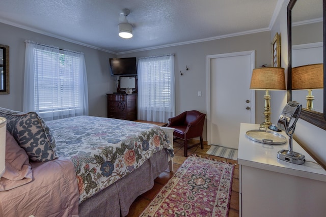 bedroom featuring a textured ceiling, ceiling fan, and ornamental molding