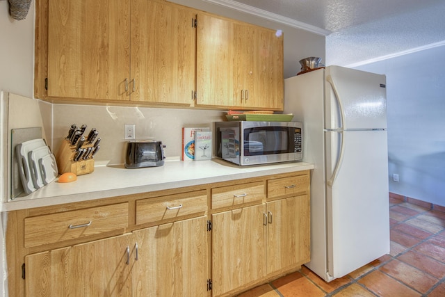 kitchen with ornamental molding, a textured ceiling, light tile patterned floors, light brown cabinets, and white fridge