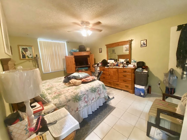 bedroom featuring light tile floors, ceiling fan, and a textured ceiling