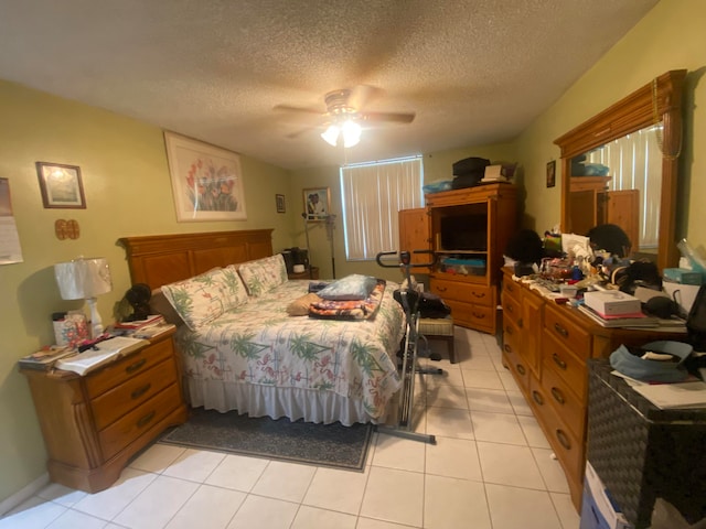 bedroom featuring a textured ceiling, light tile flooring, and ceiling fan