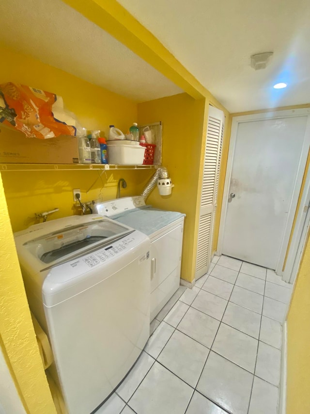 laundry room with washer and clothes dryer and light tile flooring