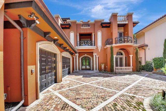 view of front of house featuring a balcony and french doors