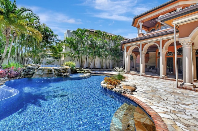 view of pool with a patio area, pool water feature, and a jacuzzi