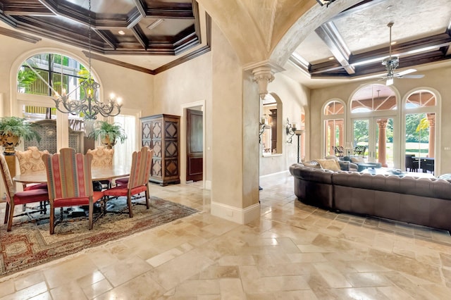 dining room featuring ornate columns, ornamental molding, coffered ceiling, ceiling fan with notable chandelier, and beam ceiling