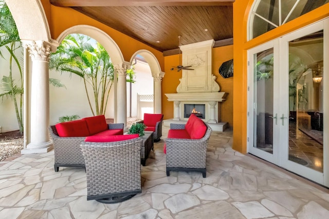 view of patio / terrace with an outdoor living space with a fireplace and french doors