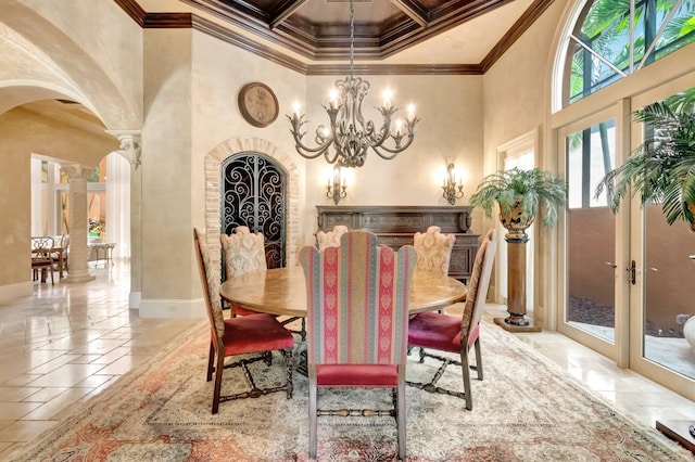 dining space featuring ornate columns, french doors, a high ceiling, an inviting chandelier, and ornamental molding