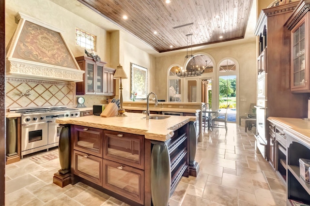 kitchen with custom exhaust hood, wooden ceiling, range with two ovens, sink, and a chandelier