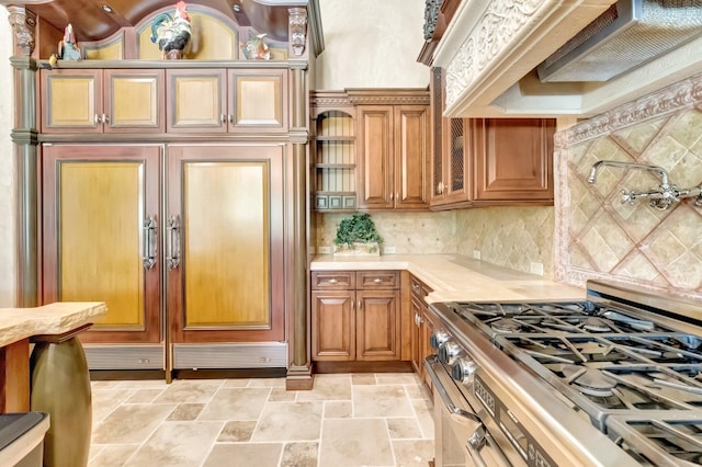 kitchen featuring custom range hood, high end stove, and tasteful backsplash