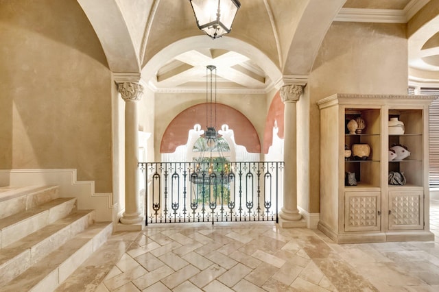 interior space with ornate columns, a towering ceiling, and an inviting chandelier