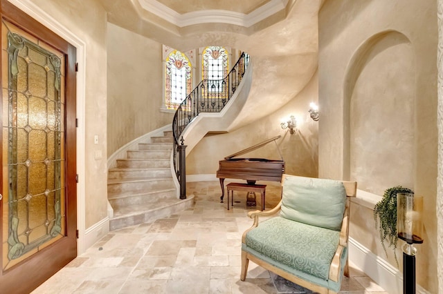 entrance foyer with crown molding and a towering ceiling