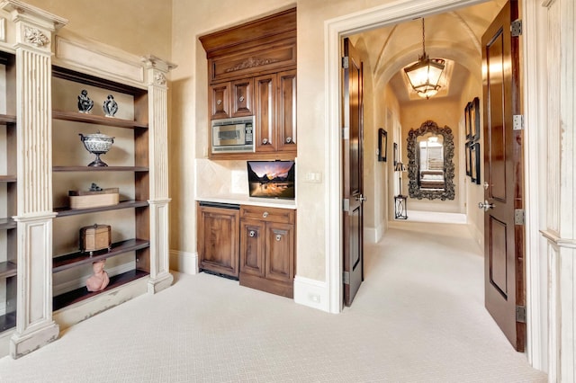 bar with light carpet, backsplash, decorative light fixtures, and built in microwave