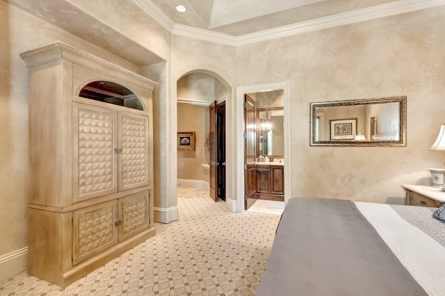 bedroom featuring vaulted ceiling, ornamental molding, and ensuite bath