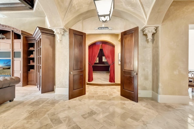 corridor with ornate columns and vaulted ceiling