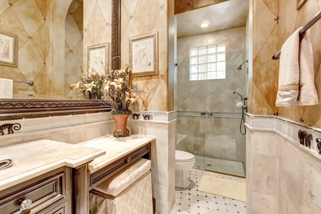 bathroom featuring tiled shower, vanity, toilet, and tile walls