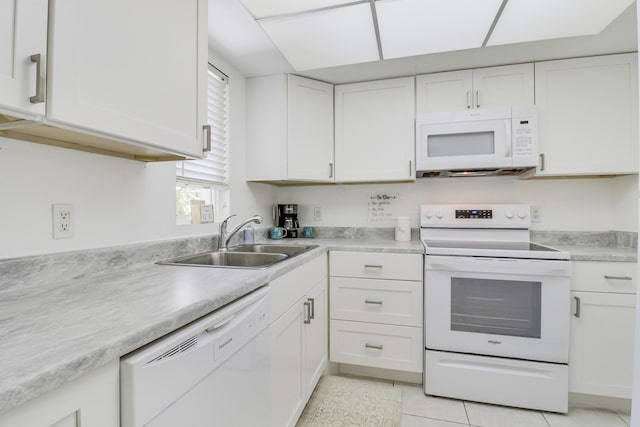 kitchen with sink, white cabinets, light tile patterned flooring, and white appliances