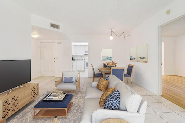 tiled living room featuring a textured ceiling