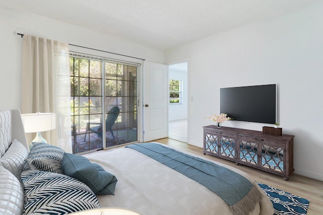 bedroom with access to exterior and light hardwood / wood-style flooring