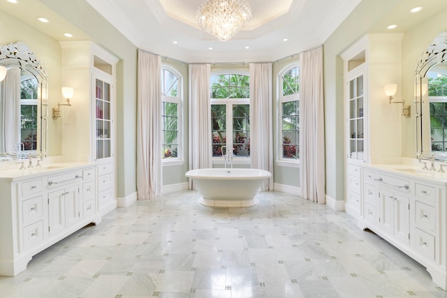 bathroom featuring vanity, a bathtub, a raised ceiling, crown molding, and a notable chandelier