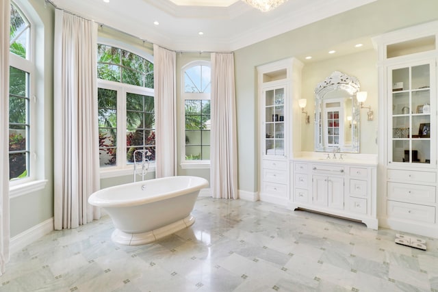 bathroom featuring vanity, crown molding, and a tub to relax in