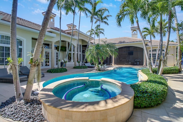 view of swimming pool featuring a patio area, an in ground hot tub, and french doors