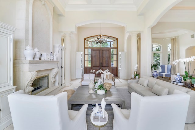 living room featuring a chandelier, a towering ceiling, plenty of natural light, and a premium fireplace