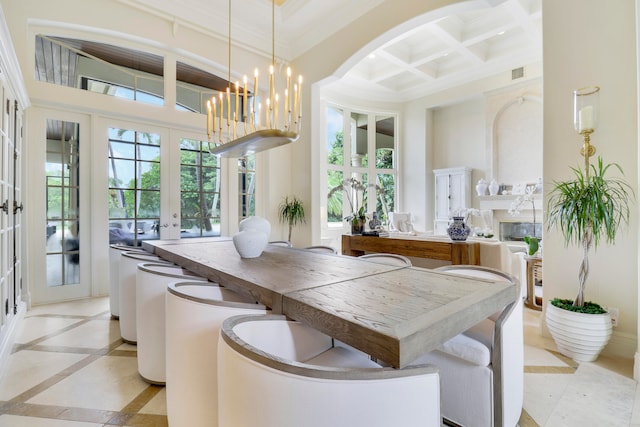 dining space featuring beam ceiling, french doors, coffered ceiling, a notable chandelier, and a towering ceiling