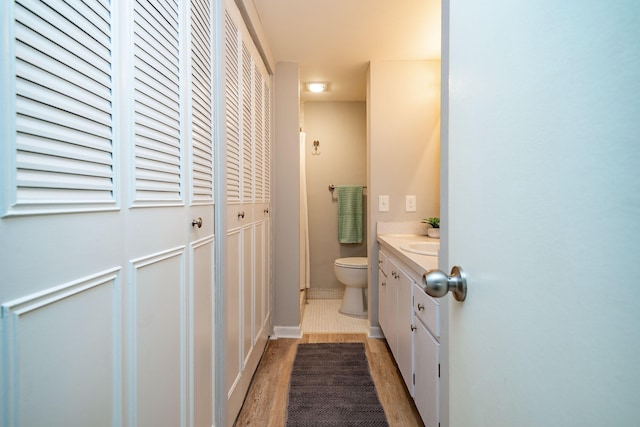 bathroom featuring hardwood / wood-style flooring, vanity, and toilet