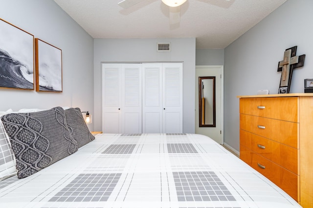 bedroom with ceiling fan, a textured ceiling, and a closet