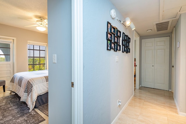 hallway featuring light tile patterned floors and a textured ceiling