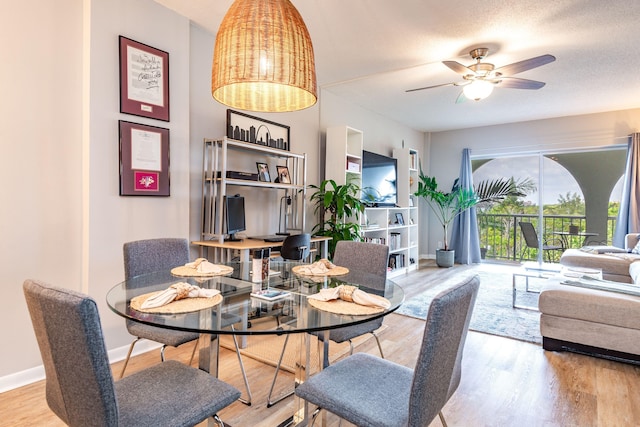 dining room with hardwood / wood-style floors, ceiling fan, and a textured ceiling