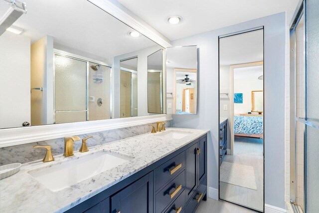 bathroom with an enclosed shower, vanity, and ceiling fan