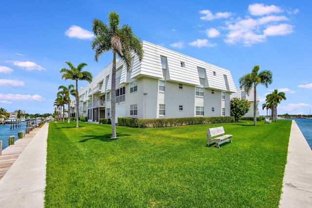 view of side of property featuring a lawn and a water view