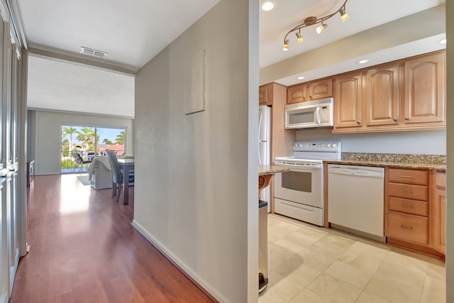 kitchen featuring white appliances and light stone countertops