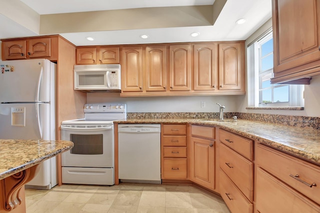 kitchen with sink, white appliances, and light stone countertops