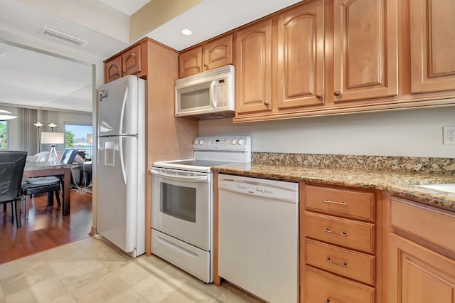 kitchen featuring white appliances and light stone countertops