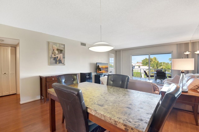 dining space featuring dark hardwood / wood-style flooring and a textured ceiling