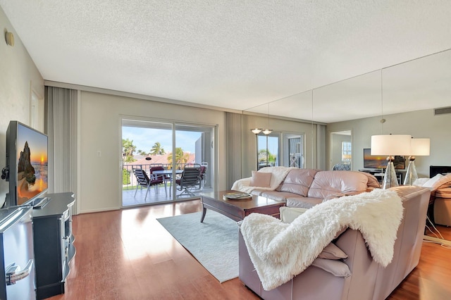 living room with a textured ceiling and light wood-type flooring